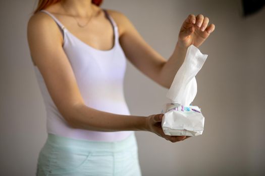 Woman taking wet baby wipes from the packaging - skin care, hygiene procedure and prevention of infectious diseases
