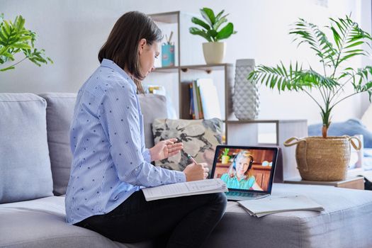 Young female teacher making video conference for child girl sitting in home office. Online meeting of student and teacher, e-learning, remote distance lesson. School, technology, teaching, knowledge