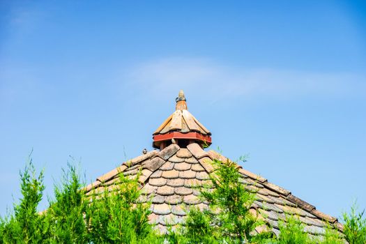 Old styled wooden pavilion with tiled roof in the garden