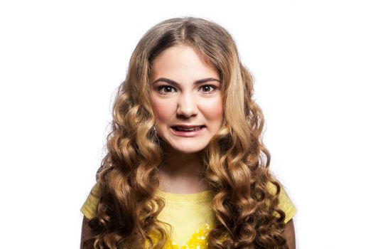 Portrait of crazy angry girl with wavy hairstyle and yellow t shirt. studio shot isolated on white background.