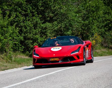 URBINO, ITALY - JUN 16 - 2022 : FERRARI TRIBUTE Ferrari F8 Spider IN an old racing car in rally Mille Miglia 2022