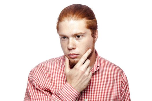 thoughtful thinking bearded readhead businessman with red shirt and freckles side looking. studio shot isolated on white.