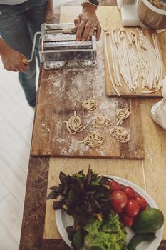The process of making noodles with noodle cutter at home on the kitchen table