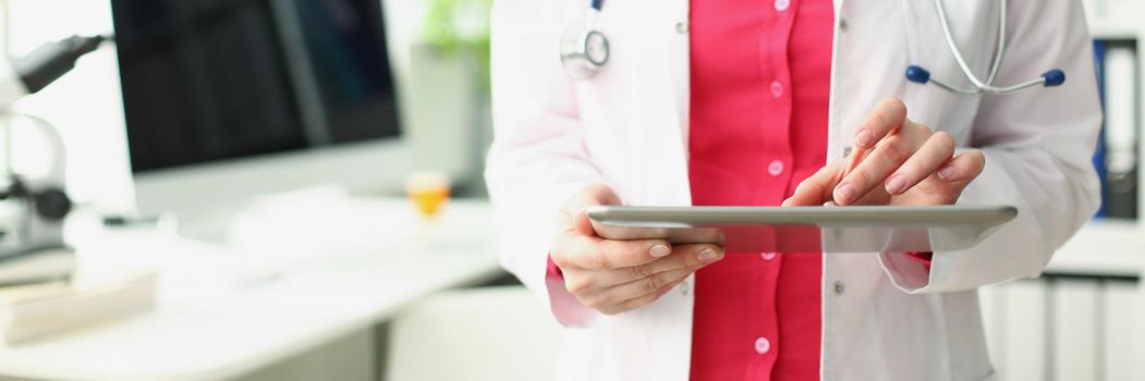 Portrait of professional medical worker use modern tablet device for work in clinic. Doctor in uniform hold new gadget. Development, healthcare concept