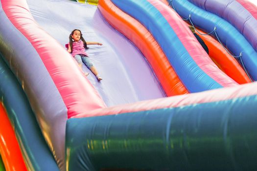 A cheerful child plays in an inflatable castle.