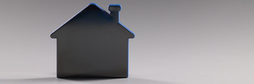 Mock up toy house standing on gray background closeup. Property for sale concept