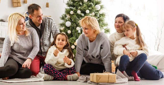 happy young family holding christmas gift and smiling.