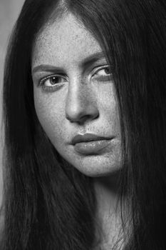 Beautiful fashion model with freckles, makeup and dark hairstyle. .Black and white photography.