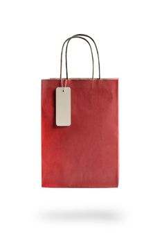 Red color paper shopping bag on white isolated background. An empty price tag hangs to insert text