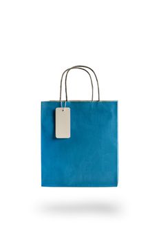 Blue color paper shopping bag on white isolated background. An empty price tag hangs to insert text