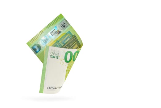 One hundred euro banknote isolated on white background. European money folded in half, close-up of money casts a shadow