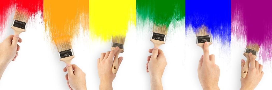 LGBT community flag. A man's hands are brushing the flag of the gay community. Rainbow close up with oil paints on white background.