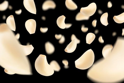 Set of peeled garlic cloves falling on a black background with selective focus. Garlic, isolated on a black background, flies down, casting a shadow