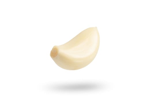 Garlic on a white background. Falling peeled clove of garlic falling on white isolated background casting shadow.