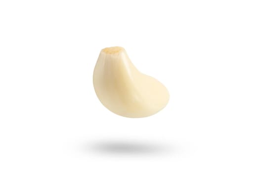 Garlic on a white background. Falling peeled clove of garlic falling on white isolated background casting shadow.