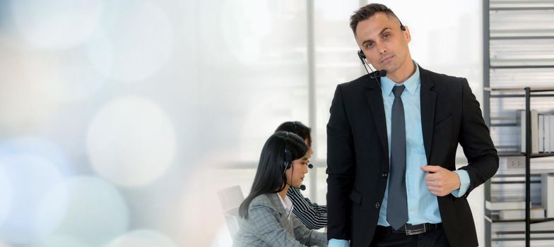 Business people wearing headset working in office to support remote customer or colleague. Call center, telemarketing, customer support agent provide service in broaden view .