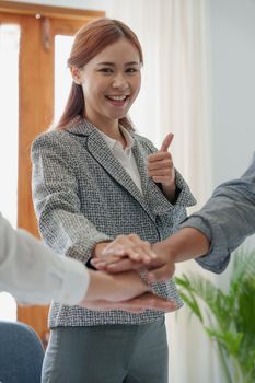 Group of business people putting their hands working together on wooden background in office. group support teamwork agreement concept.