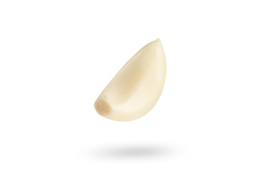 Garlic on a white background. Falling peeled clove of garlic falling on white isolated background casting shadow.