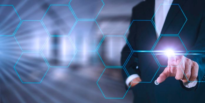 Businessman pressing button on hologram virtual screens with hexagons and transparent. Business technology internet and virtual reality concept.