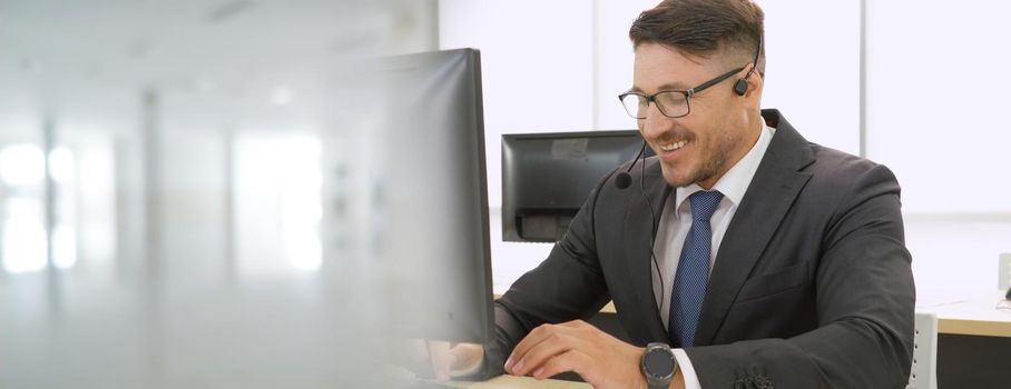 Business people wearing headset working in office to support remote customer or colleague. Call center, telemarketing, customer support agent provide service in broaden view .