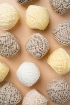 pastel and beige colored yarn wool on beige backdrop, top view flat lay. Knitting pattern