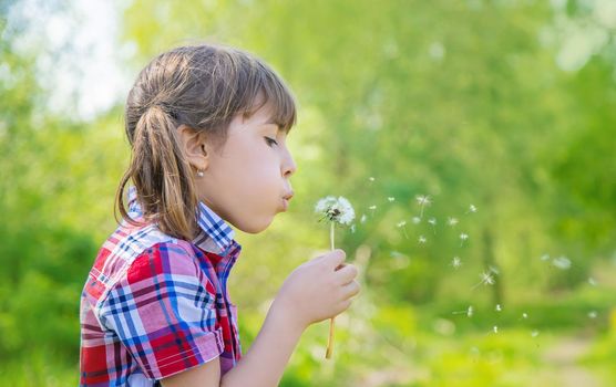 Child girl with dandelions in the park. Selective focus.