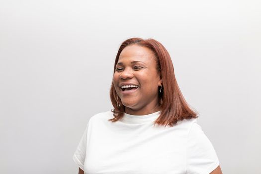 Portrait of a black woman client posing and smiling with joy for the camera after recieving treatment at the dental clinic hall