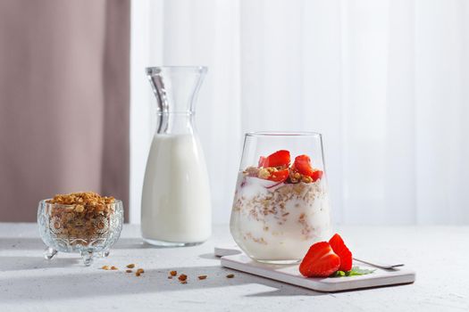 A glass of healthy yogurt with fresh berries and granola on a gray background.Healthy breakfast.