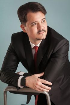 Closeup portrait of confident business man. Indoor, studio shot, isolated on light blue or gray background