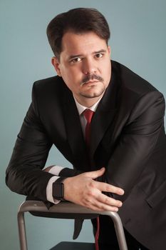 Portrait of business man in classic stylish suit. Indoor, studio shot, isolated on light blue or gray background