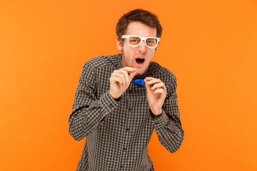 Funny manager looking at camera with disgust look. Indoor, orange background