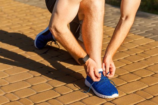 Tie shoelaces. Blue sneakers. Runnig. Pause