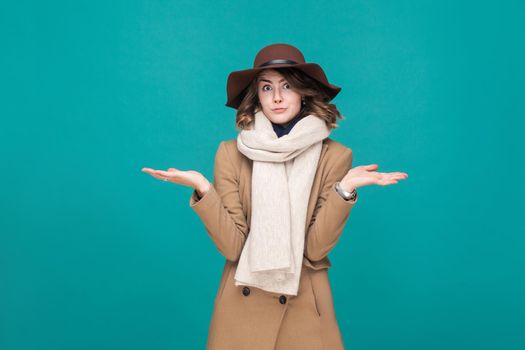 Autumn, fall concept. Confusion and pondering cute woman looking at camera. Indoor shot