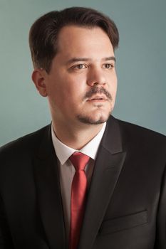 Closeup portrait of successful business man. Indoor, studio shot, isolated on light blue or gray background