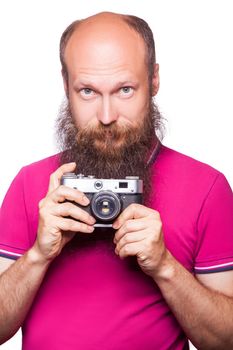 The portrait of bald bearded man photographer with pink t shirt holding classic camera. isolated on white background. studio shot.