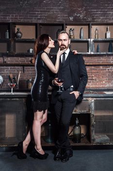 Handsome fashion couple drinking at a party. Studio shot