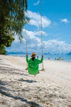 woman on the beach of the tropical Island Naka Island near Phuket Thailand, a woman on a swing on the beach in Thailand