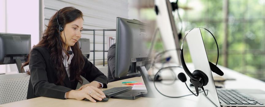 Business people wearing headset working in office to support remote customer or colleague. Call center, telemarketing, customer support agent provide service in broaden view .