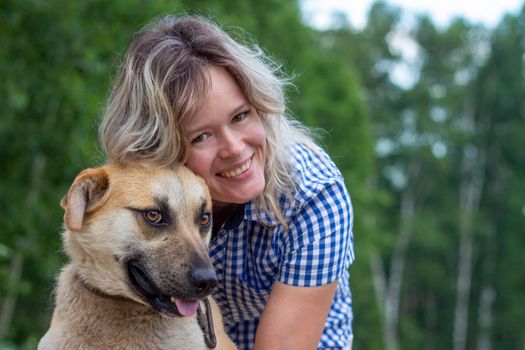 Beautiful yong woman is cuddling cute dog in the farm expressing animal love like a friend, this dog is domesticated to help and share in human life.