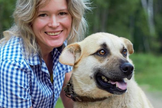 Beautiful yong woman is cuddling cute dog in the farm expressing animal love like a friend, this dog is domesticated to help and share in human life.