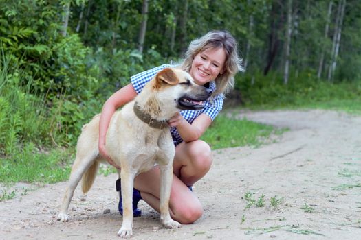 Beautiful yong woman is cuddling cute dog in the farm expressing animal love like a friend, this dog is domesticated to help and share in human life.
