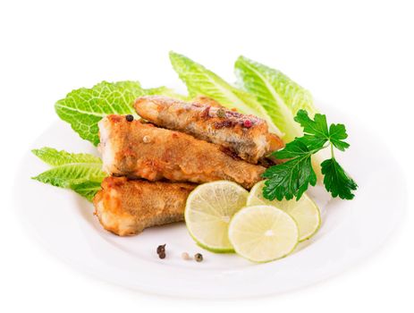 appetizing fried fish fillet with vegetables and herbs on a white plate