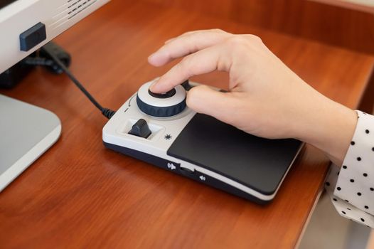 A woman uses a special magnification device for the visually impaired