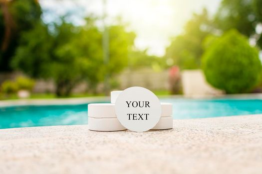 Close-up of chlorine tablets for swimming pool cleaning with space for text, chlorine tablets on the edge of a swimming pool, chlorine tablets for swimming pool disinfection