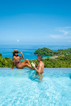 a young couple of men and women at a swimming pool during a vacation on a tropical island. man and woman in infinity pool during sunset. luxury vacation in Thailand pool of a luxury pool villa