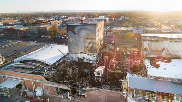 Aerial view of a production plan heavily damaged by fire in teh middle of the city