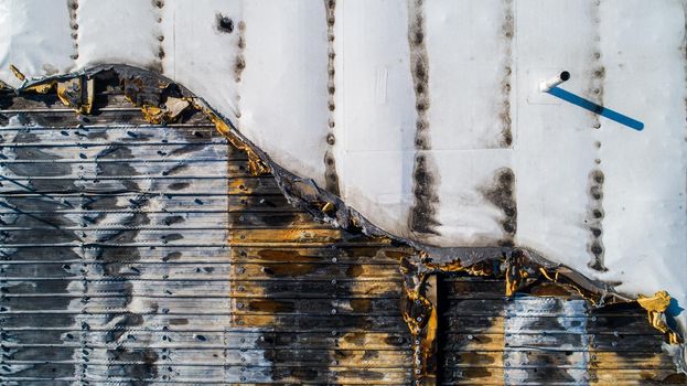 aerial view of a roof of a building that has been burned and suffered heat damage