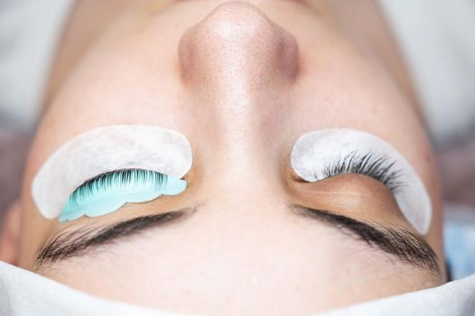 Close-up portrait of a woman in a beauty salon on eyelash lamination procedure