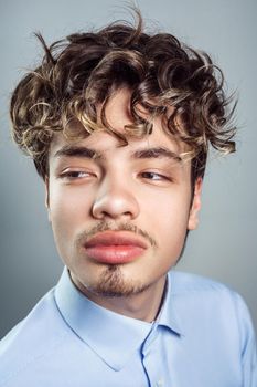 Portrait of young man with curly hairstyle. studio shot.