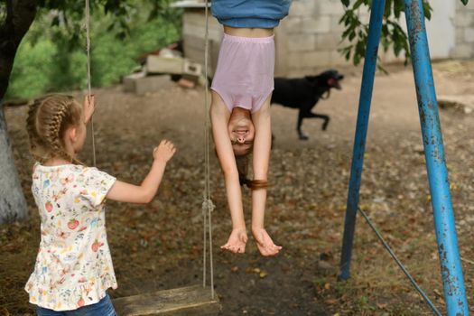 The girls play in the yard in the village